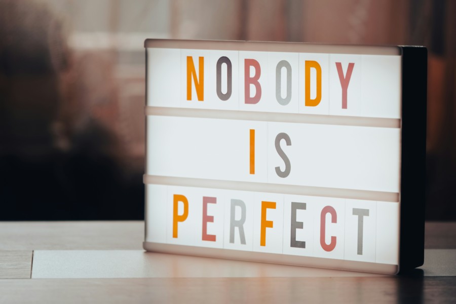 A photo of a lightbox with colourful lettering spelling out "NOBODY IS PERFECT" on 3 different lines.