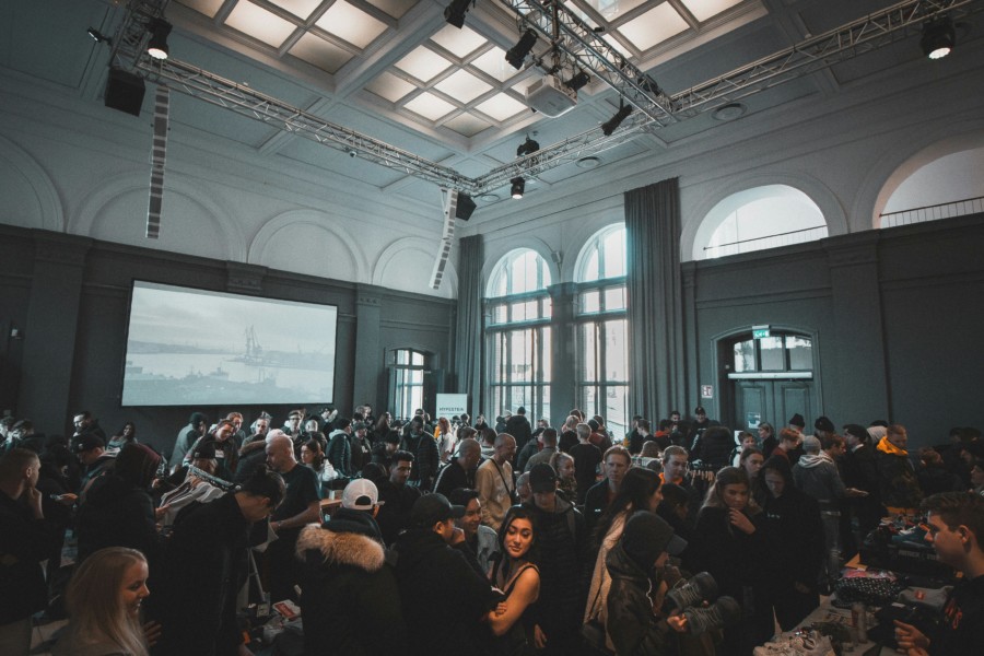 A photo of a packed conference presentation room viewed from the back.