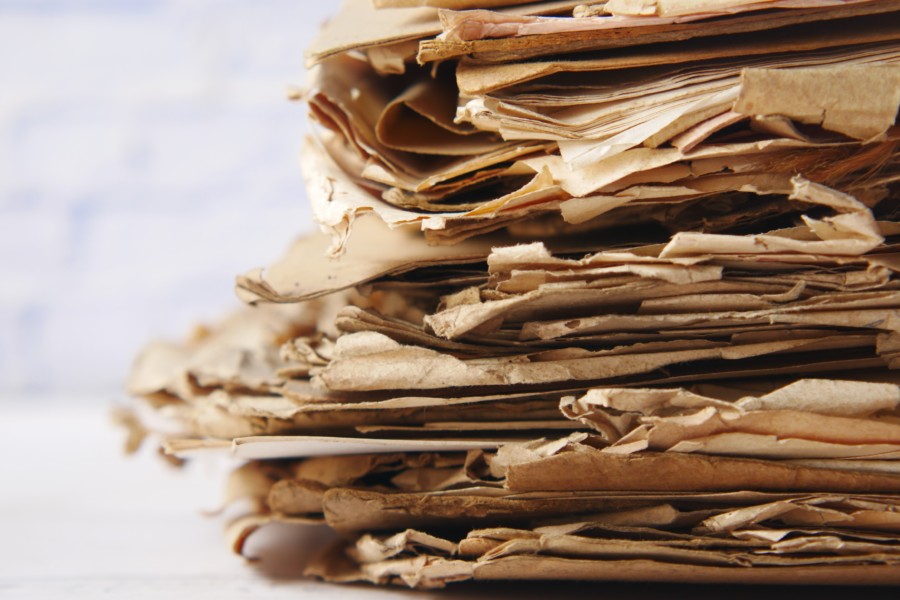 a loose stack of old weathered parchment papers with very rough edges