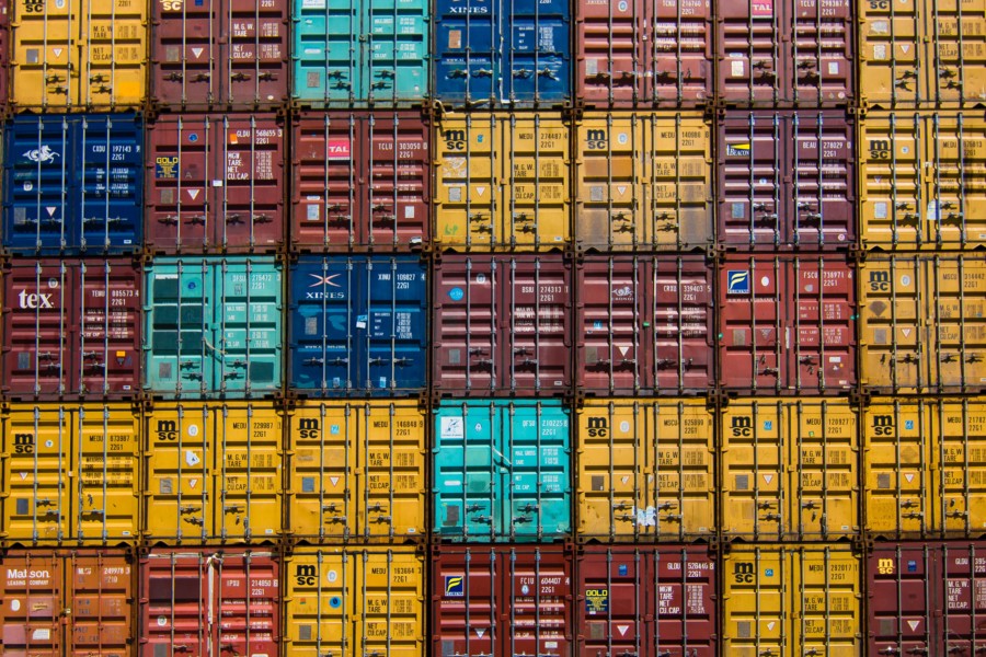 A full screen photo of a huge stack of multi-coloured shipping containers arranged in a tight grid