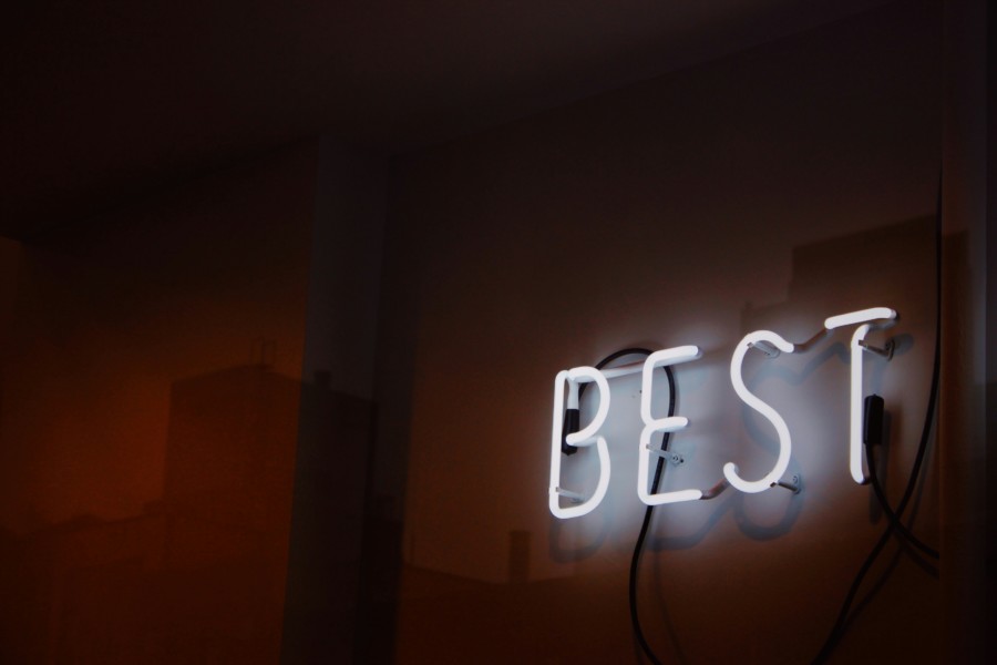 A photo of a neon sign that has been shaped into the word "BEST" in a white glowing light on a dark background.