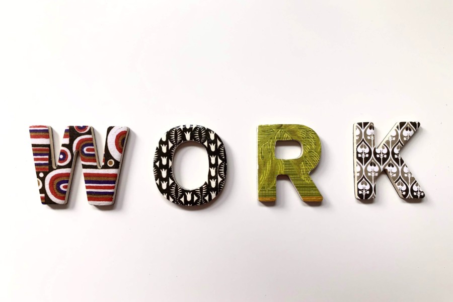 the word "WORK" spelled out in wooden letters covered in multi-colour patterns on a white