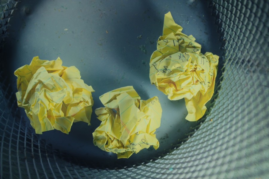 3 scrunched up balls of yellow paper viewed in a metal mesh bin from above so only the base and sides of the bin are visible to a minimal and focused effect.