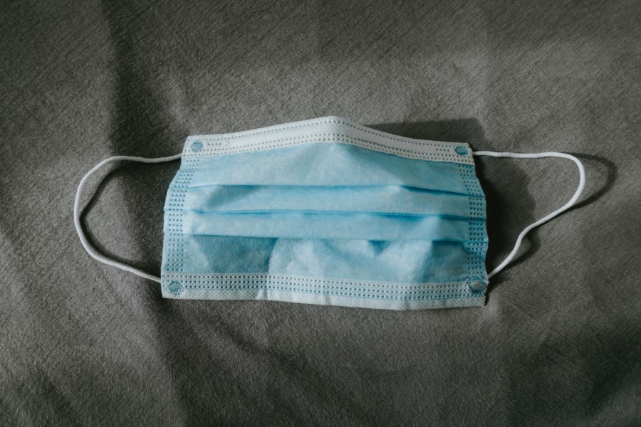 Blue surgical mask on a grey surface