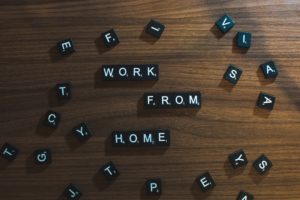 black scrabble letters arranged to spell out "work from home" during these pandemic times.