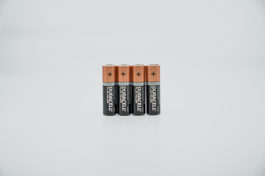 Four double A batteries displayed vertically next to each other on a light grey background