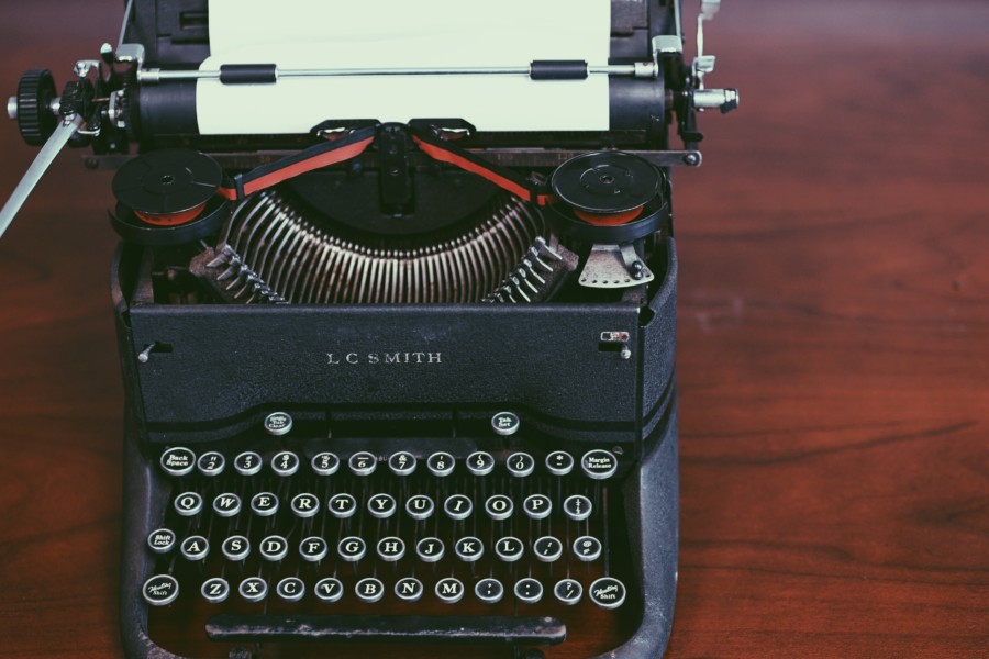 A vintage typewriter on a dark wooden desk