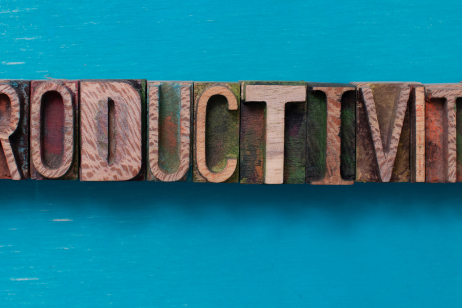 wood block letters in various fonts spelling out "productivity" on a bright blue background