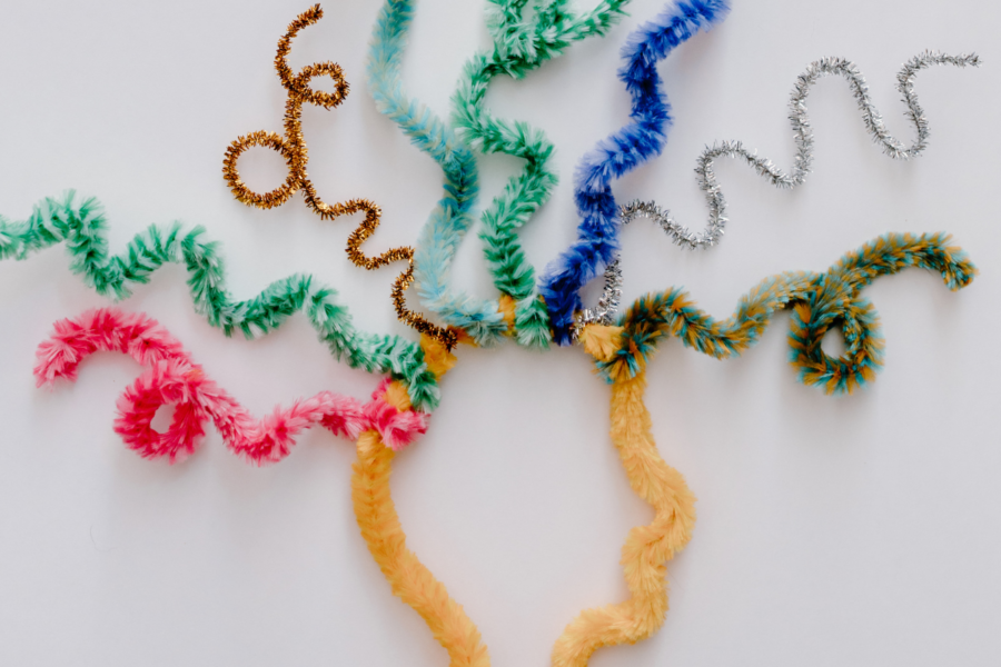 A variety of colourful pipe cleaners are used to shape the outline of a human head in profile with lots of squiggly lines seeming to 'explode' from the top of the head on a plain white background.